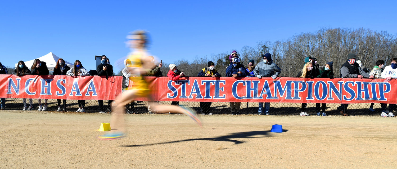 Bundled in warm clothes, spectators look on as runners approach the finish line at the NCHSAA state cross country meet last January. The two-day championship event, typically held in early November, featured over 760 participants from across North Carolina.